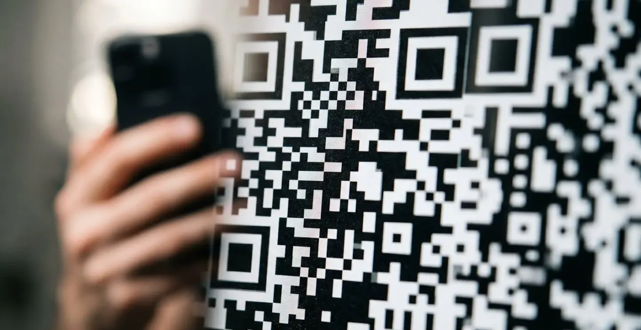 Détail macro d'un code QR affiché sur un écran, symbolisant la modernité et la simplicité du paiement mobile en Belgique.